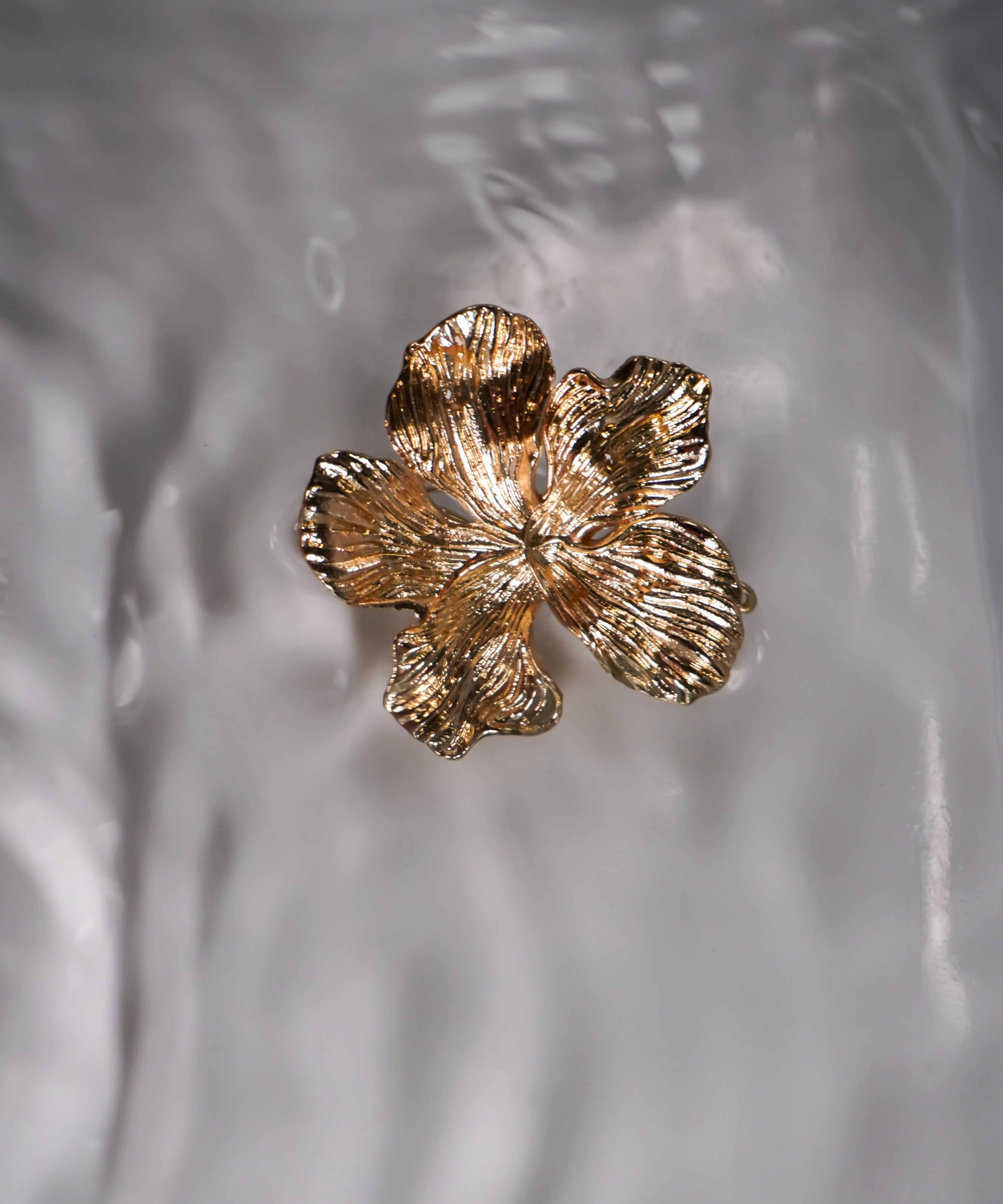 A gold metal flower swimwear clip.